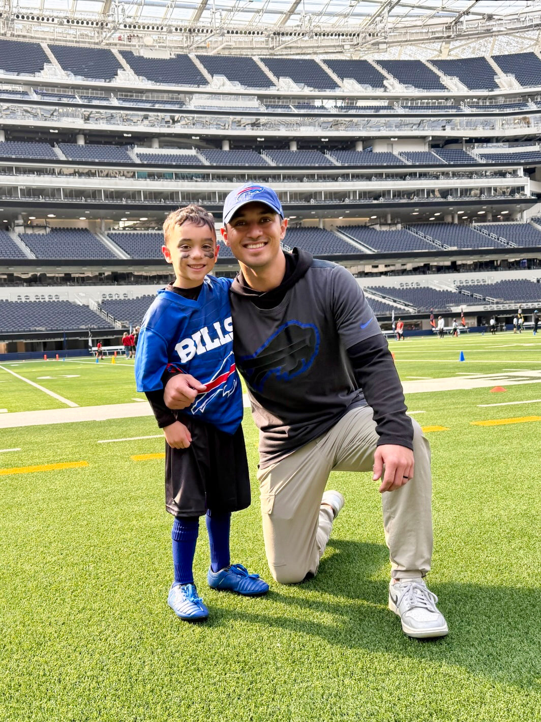 Father and son on the field for a flag football game at SoFi Stadium